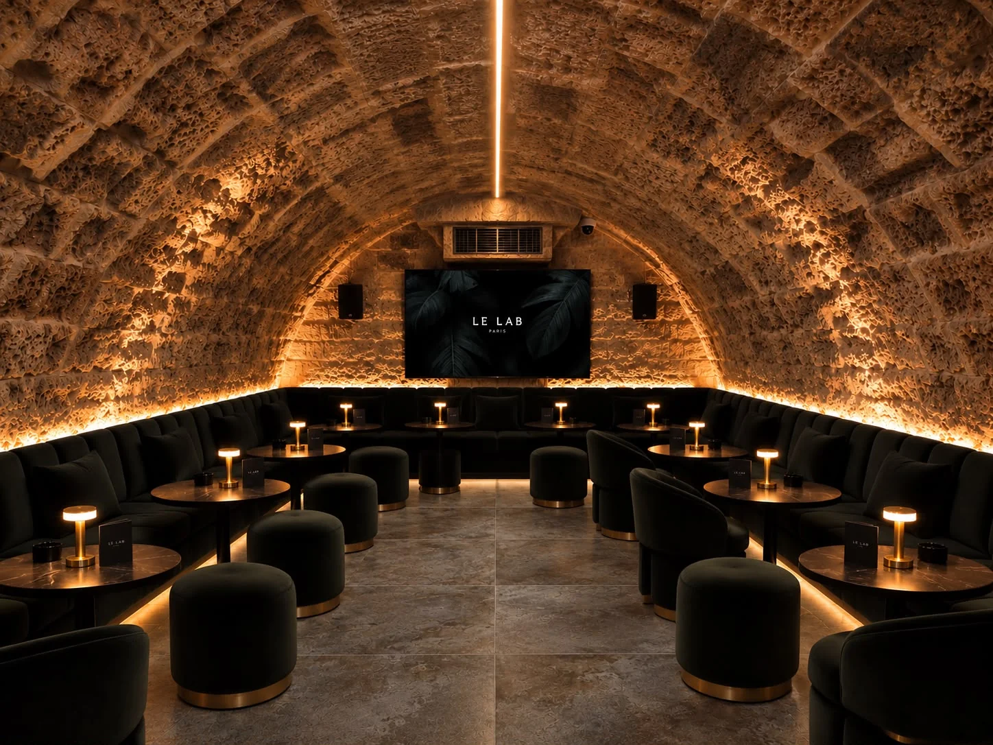 Salon voûté Le Lab avec banquettes, tables et lumière indirecte